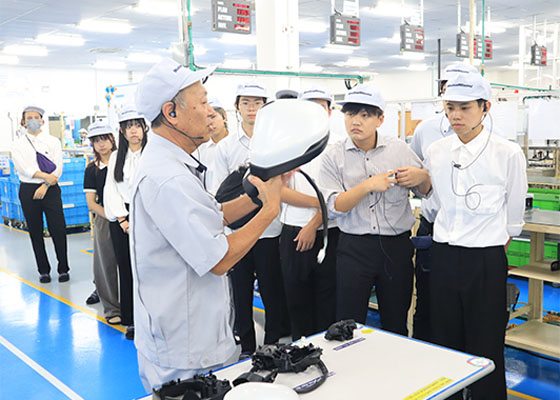 装置の前で解説を行う社員と学生