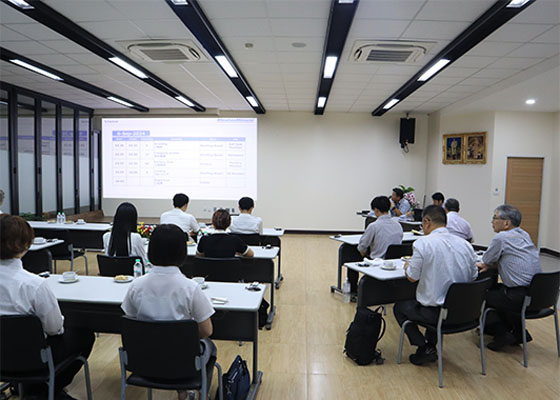 Participants listening to a business overview presentation indoors.